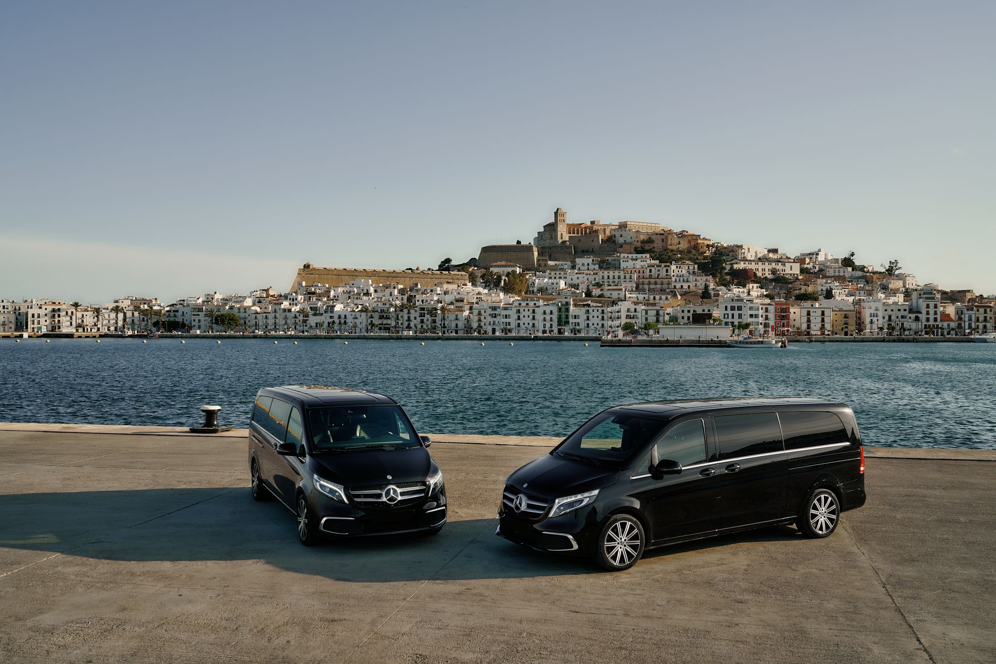 Vans in Ibiza with old town in the landscape
